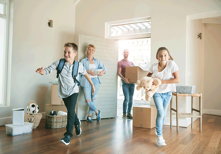 Kids run into room while parents are at door holding boxes