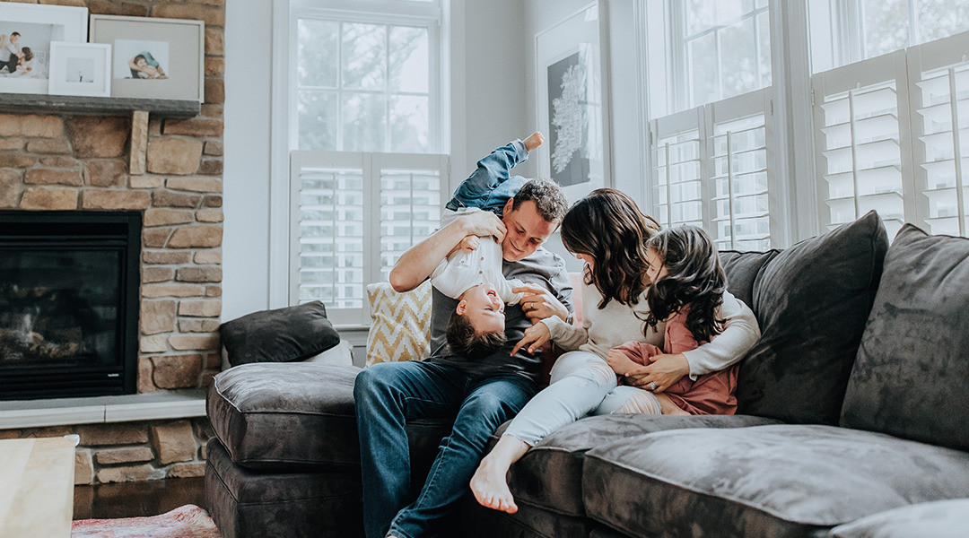 Family on living room couch laughing and having fun