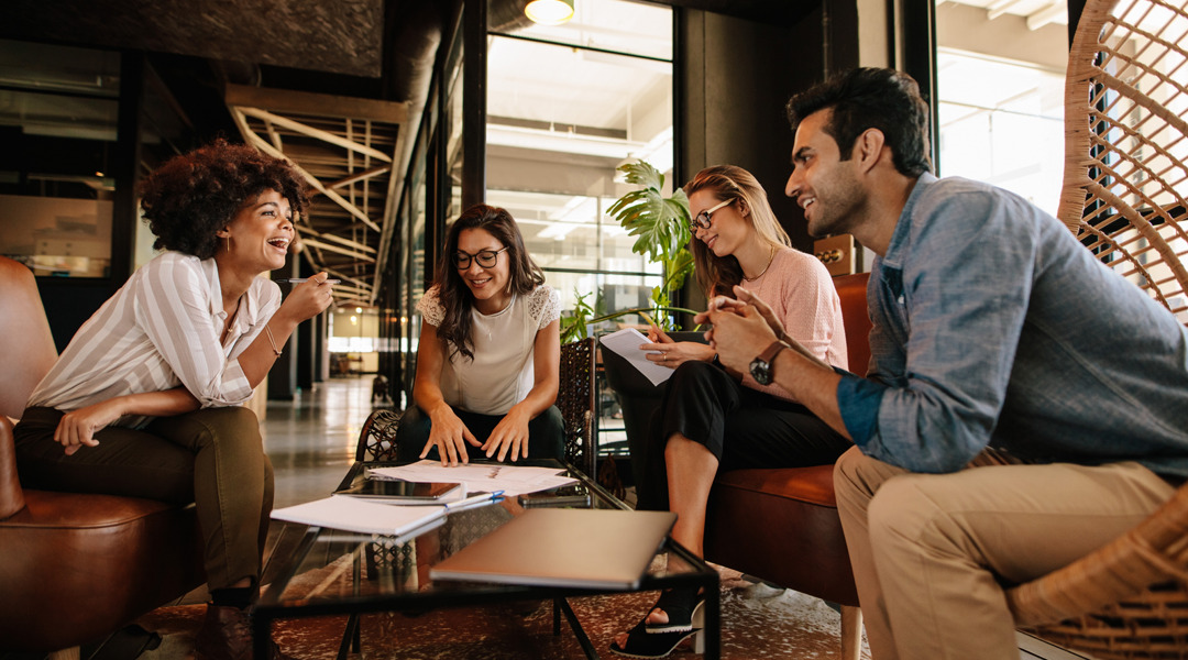 Group of people sit around a coffee table for meeting