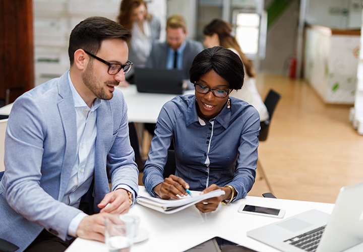 Man and woman sit at table and review paperwork