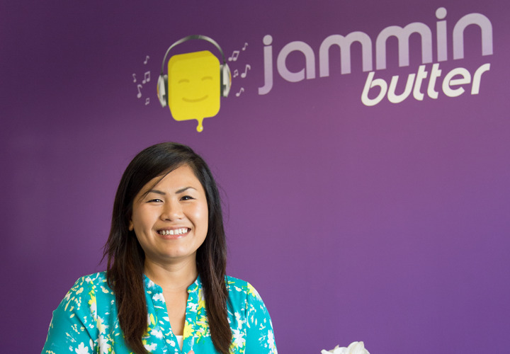 Jammin Butter logo on purple wall with smiling Vantha
