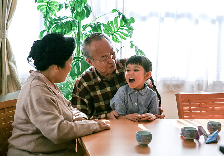 Woman and man are seated at a table with little girl