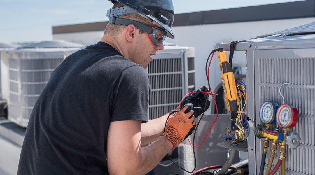 HVAC service technician performing maintenance on HVAC unit