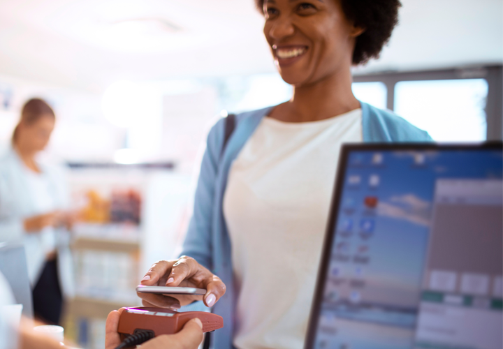 Smiling woman uses contactless payment for purchase