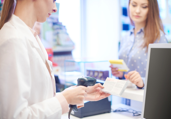 Woman scanning a product bar code at counter