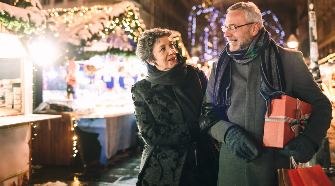 A couple is out shopping in the evening with presents.