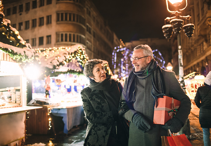 A couple is out shopping in the evening with presents.