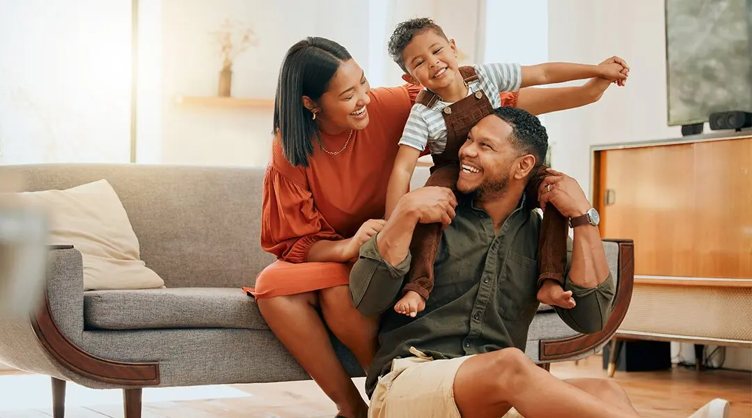 Happy family shares a fun moment in their living room.