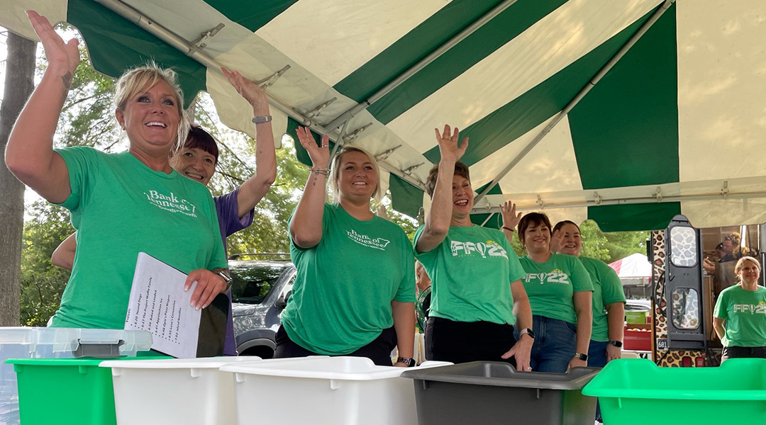 Bank of Tennessee volunteer employees waving at Funfest.